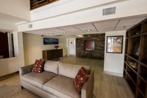 a living room with a couch and a brick wall at Red Roof Inn PLUS+ Houston - Energy Corridor in Houston