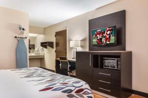 a hotel room with a bed and a flat screen tv at Red Roof Inn Texarkana in Texarkana