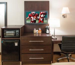a room with a desk with a tv and a football player at Red Roof Inn Benton Harbor - St. Joseph in Benton Harbor