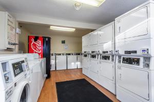 a laundry room with white washers and a soda machine at HomeTowne Studios by Red Roof Atlanta NE – Norcross South in Norcross