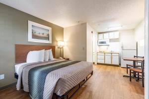 a hotel room with a bed and a kitchen at HomeTowne Studios by Red Roof Atlanta NE - Peachtree Corners in Norcross +23 photos