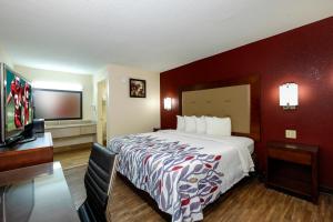 Habitación de hotel con cama y TV de pantalla plana. en Red Roof Inn Columbus, MS, en Columbus