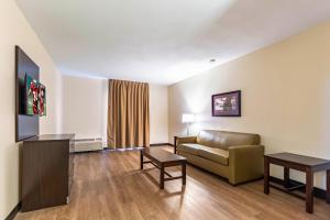 a living room with a couch and a tv at Red Roof Inn PLUS & Suites Houston - IAH Airport SW in Houston