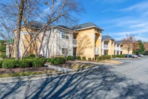 a house on a street with a driveway at HomeTowne Studios by Red Roof Atlanta NE - Peachtree Corners in Norcross