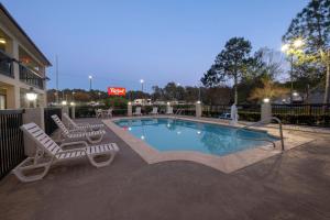 uma piscina com duas espreguiçadeiras e um hotel em Red Roof Inn Gulf Shores em Gulf Shores
