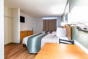 a hotel room with a bed and a table at HomeTowne Studios by Red Roof - Atlanta NE - Peachtree Corners in Norcross