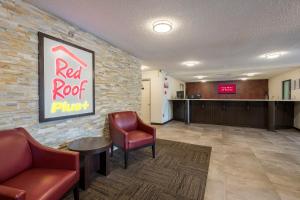 a waiting room with two chairs and a red roof purse at Red Roof Inn PLUS+ & Suites Opelika in Opelika