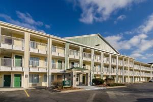 an exterior view of an apartment building with a parking lot at HomeTowne Studios by Red Roof Denver - Glendale/ Cherry Creek in Denver