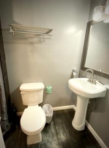 uma casa de banho com um WC branco e um lavatório. em Sheridan Hostel em Dania Beach