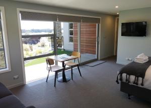 een slaapkamer met een bed en een tafel en stoelen bij High Country Retreat - Lake Tekapo in Lake Tekapo