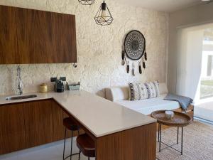 a kitchen with a counter top and a living room at Kaanal Tulum in Tulum