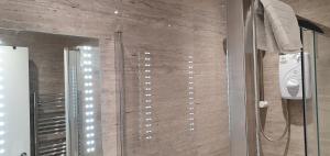 a bathroom with a glass shower with a mirror at Garland Stylish Apartment 2 In Greater London in London