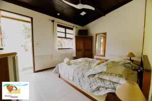 1 dormitorio con cama y ventana grande en Pousada Caúca en Ilha Grande