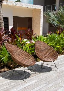 two wicker chairs sitting on a wooden deck at Kaanal Tulum in Tulum