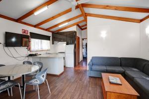 una sala de estar con un sofá y una mesa en BIG4 Taggerty Holiday Park, en Taggerty
