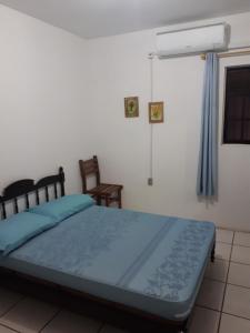 a bedroom with a bed with blue sheets and a fan at Casa na praia 02 in Itapema