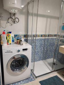 コラレホにあるAppartamento privato Oasis Tamarindoのバスルーム(シャワー付)の洗濯機が備わります。