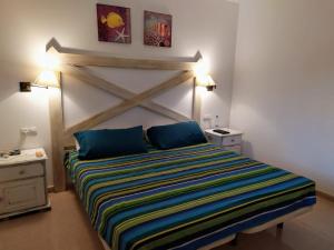 コラレホにあるAppartamento privato Oasis Tamarindoのベッドルーム1室(大型ベッド1台、ストライプ毛布付)