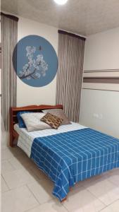 a bedroom with a blue bed with a blue blanket at Rumanija's Airport Rooms in Zanderij