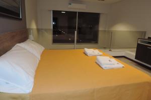 1 cama grande con 2 toallas encima en Hanan Pacha - Apart Salta en Salta