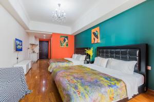 2 camas en una habitación con paredes de color naranja y azul en Lavender Apartment, en Guangzhou