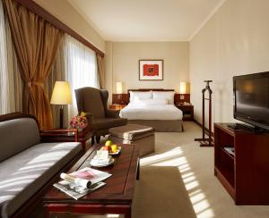 a hotel room with a bed and a television at The Howard Plaza Hotel Taipei in Taipei