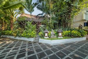 
a garden area with a stone wall and a fire hydrant at Hotel Tugu Blitar in Blitar
