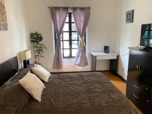 een slaapkamer met een groot bed en een raam bij La Histórica CDMX in Mexico-Stad