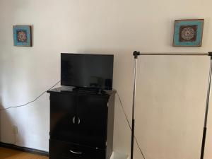 a flat screen tv sitting on top of a black dresser at La Histórica CDMX in Mexico City