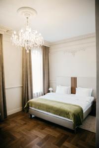 Hotel Amurskiy في إيركوتسك: غرفة نوم بسرير كبير وثريا