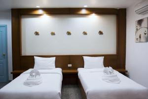 dos camas sentadas una al lado de la otra en una habitación en Mosaik Apartment en Pattaya South