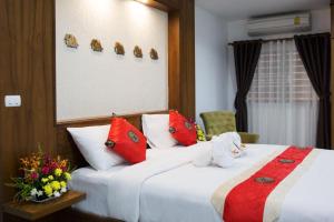 a hotel room with two beds with red and white pillows at Mosaik Apartment in Pattaya South