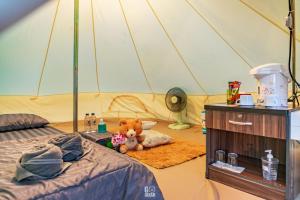 a bedroom with a tent with a teddy bear on the floor at ภูชวนหลง ม่อนแจ่ม in Chiang Mai