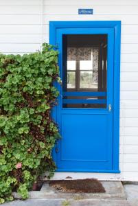a blue door on a house with a bush at Polperro, a quintessential seaside experience in Robe