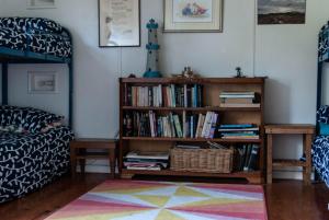 a living room with a book shelf filled with books at Polperro, a quintessential seaside experience in Robe