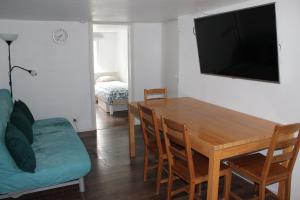 ein Wohnzimmer mit einem Tisch, einem Sofa und einem TV in der Unterkunft Helsinki Hideaway in Helsinki