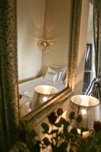 einem Spiegel, der ein Schlafzimmer mit einem Bett reflektiert in der Unterkunft Riad Golfame in Marrakesch