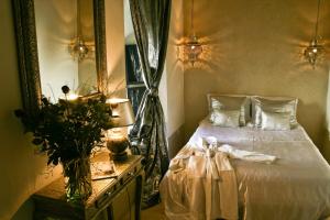 a bedroom with a white bed and a mirror at Riad Golfame in Marrakesh