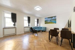 a living room with a blue couch and chairs at Apartsee Wellness Plzeň in Plzeň