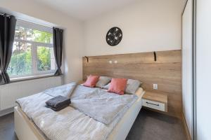 a bedroom with a bed and a clock on the wall at Apartsee Wellness Plzeň in Plzeň