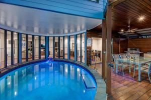 a large swimming pool in a house with a table at Nautilus on Hamilton Island by HIHA in Hamilton Island