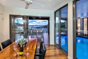 a dining room with a table and chairs and a pool at Nautilus on Hamilton Island by HIHA in Hamilton Island