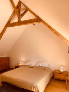een slaapkamer met een bed op de zolder bij Ferme des Trois Poiriers, Teloché in Teloché