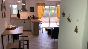 a kitchen and living room with a table and a dining room at La Casita in Chasseneuil-du-Poitou