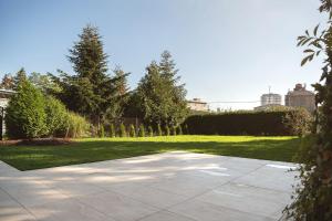 a garden with grass and trees and a driveway at Apartsee Wellness Plzeň in Plzeň