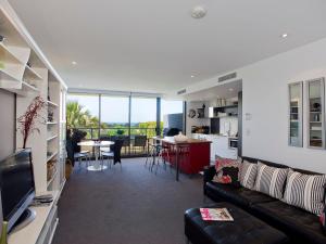 a living room with a couch and a dining room at Lorne Chalet Apartment 10 in Lorne