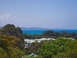 a group of houses on a hill next to the water at Lorne Chalet Apartment 10 in Lorne