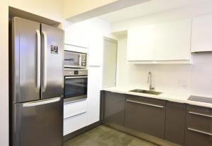 a kitchen with stainless steel appliances and white cabinets at Glabur Stays - The Amazing 1 BDR - Executive apt Nicosia Center Free Parking & WiFi in Nicosia