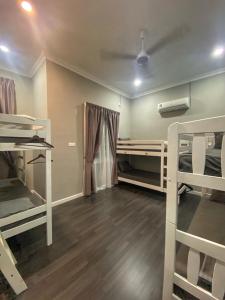 a room with two bunk beds and a room with wooden floors at Shafickza Guesthouse in Kuala Terengganu