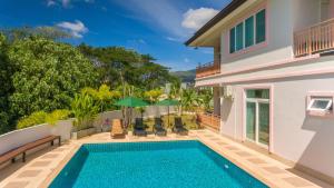 a villa with a swimming pool and a house at Phuket9 Residence in Chalong 